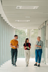 Colleagues walking and discussing in modern office hallway, collaborating on business ideas and...