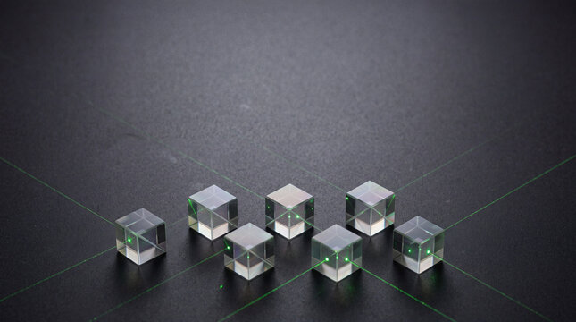 Transparent glass cubes connected by green lines across a dark textured surface. Artificial intelligence and cybersecurity network concept. Data connection and digital infrastructure.
