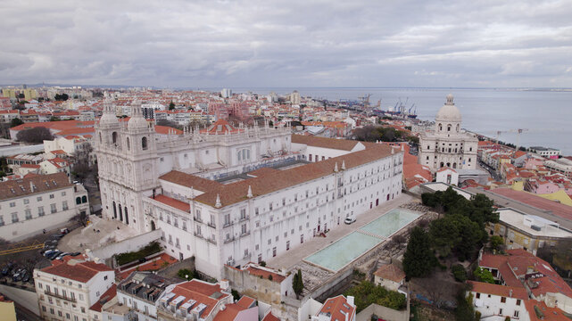 Aerial view of the Church of St. Vincent de Fora with its historic white facade, twin towers, and terracotta roofs, set within the urban landscape of Lisboa, Lisboa, Portugal.