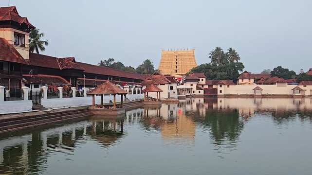 Scenic Wide View of Pigeons Taking Flight Over Padma Theertham Tank Revealing Golden Gopuram Tower of Sree Padmanabhaswamy Temple, Capturing Sacred Heritage and Devotion of the Richest Shrine