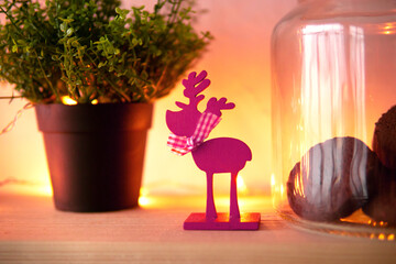 Wooden reindeer ornament on a decorated Christmas interior table. Holiday home decoration and seasonal styling. Festive winter celebration. Cozy Christmas still life with greenery and glass © Анна Маркина