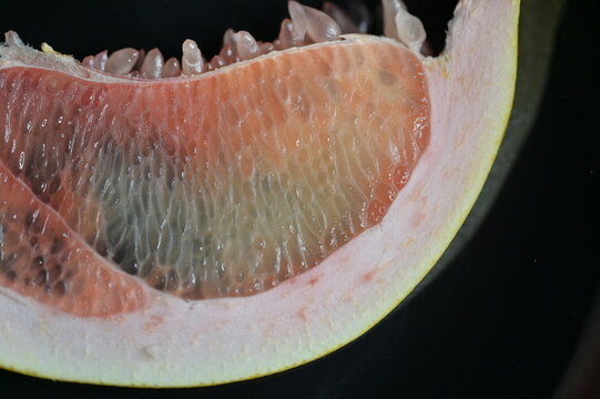 Macro shot pulp structure of a pink grapefruit slice. Good for health publications, fresh juice branding, fruit backgrounds, abstract macro collections