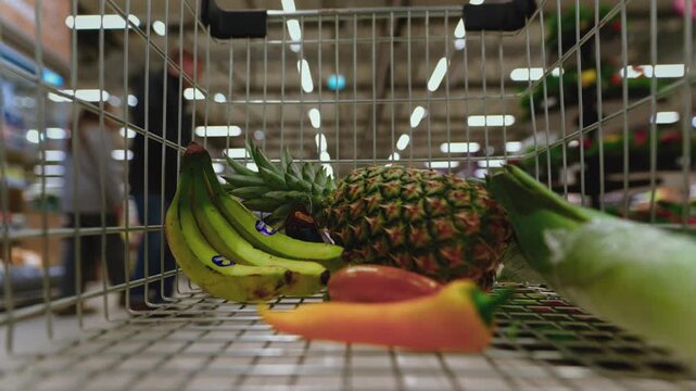 First person timelapse of a shopping cart moving through supermarket aisles filled with products. Concept of consumerism, excessive consumption, consumer lifestyle and society driven by shopping.