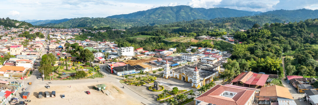 Aerial view of San Agustin town featuring the central church, surrounding rooftops, and lush green hills in San Agustin, Huila, Colombia.