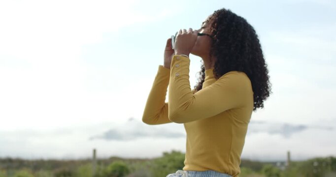 African American adult woman lifting sunglasses to eyes, tucking hair at poolside, viewing horizon