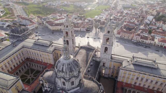 Aerial view of the Palace of Mafra, showing its grand basilica, twin bell towers, and the surrounding town square in Mafra, Lisbon, Portugal.