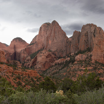 Steep sandstone red cliffs of Kolob Canyon in Zion National Park on a stormy, cloudy day