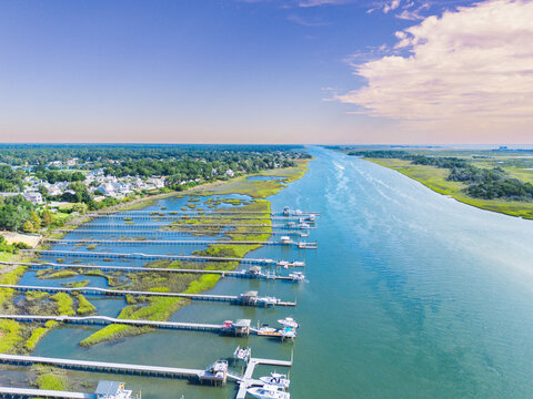 Aerial view of the Intracoastal Waterway with private boat docks extending into the water, surrounded by marshlands and residential homes in Wrightsville Beach, North Carolina, United States.