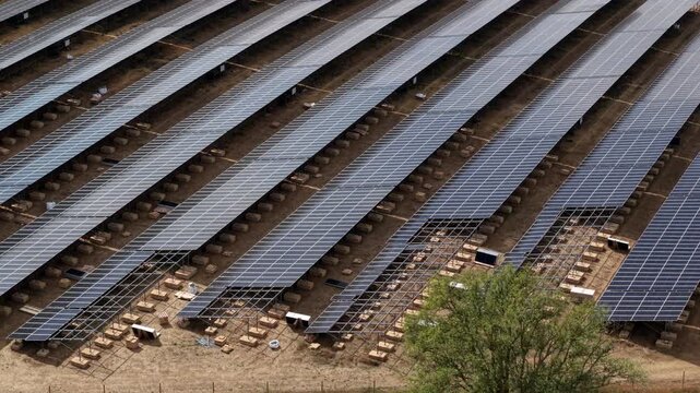 Close up aerial view of photovoltaic solar panels and metal mounting frames under construction on a rural site in England, UK
