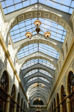 Glass roofed arcade with arched ceiling and hanging chandelier