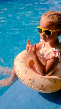 Children are swimming and playing in the pool. Selective focus.