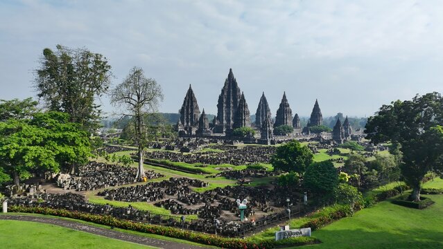 Aerial view of Prambanan Temple complex with iconic stone spires, lush green lawns, and archaeological ruins in Kecamatan Prambanan, Daerah Istimewa Yogya, Indonesia.