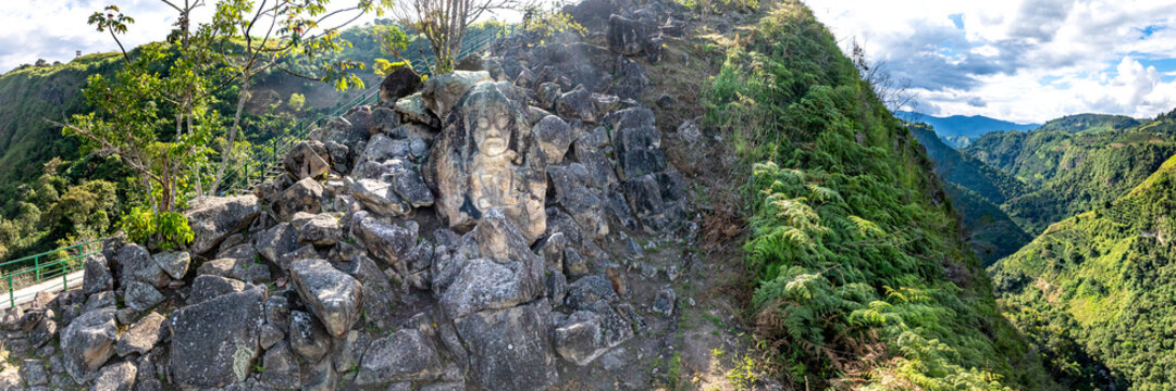 Aerial view of La Chaquira, an ancient stone carving set among rocky terrain and lush vegetation overlooking a deep canyon in San Agustin, Huila, Colombia.