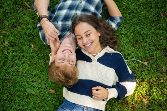 Young couple enjoying happy moment lying on grass