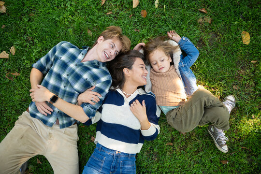 Family lying on grass enjoying togetherness outdoors