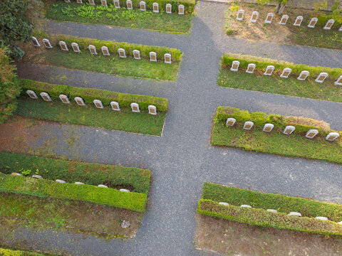 Aerial view of the Eppegem military cemetery featuring rows of white headstones set within manicured green hedges and gravel pathways in Zemst, Flanders, Belgium.