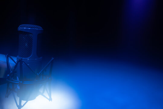 Studio microphone for broadcasting and vocals with blue light glare and copy space