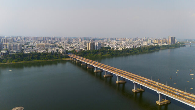 Aerial view of the bridge spanning the Tapi River with urban buildings and lush greenery along the riverbanks in Surat, Gujarat, India.