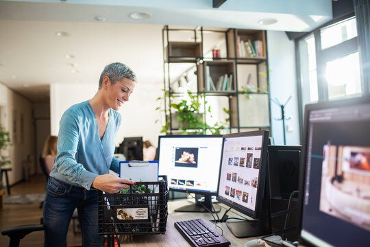 Woman receiving organic produce box at office desk