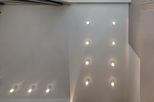 suspended ceiling with halogen spots lamps and drywall construction in empty room in apartment or house. Stretch ceiling white and complex shape.