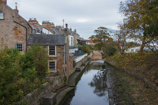 Scenic view of a traditional canal and historic stone houses in the coastal town of Anstruther, Fife, Scotland