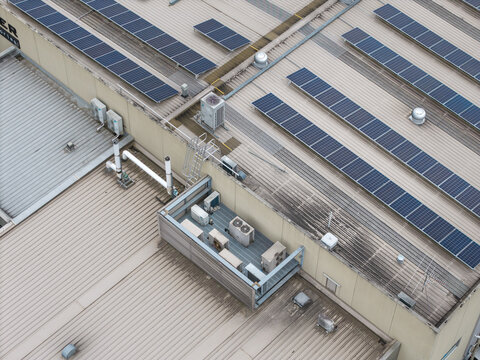 Melbourne, VIC, Australia - 14 October 2026: Aerial view of Bayswater North Factories featuring rows of solar panels installed on corrugated metal roofs and industrial HVAC units.