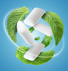 Menthol chewing gum pieces and mint leaves in air against blue background © New Africa