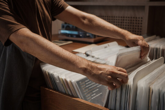 Hands flipping through vinyl records in music store, man browsing album sleeves and searching for LP music, analog sound collection, retro shopping and nostalgic entertainment.