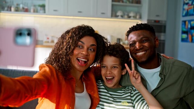 Closeup pink smartphone hands. Smiling family taking selfie sofa living room.