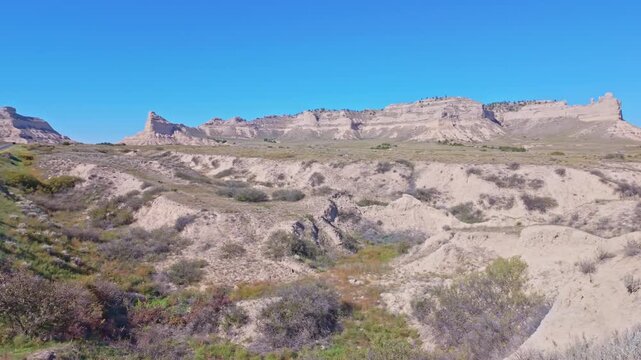 Road view of asphalt highway winding toward towering sandstone bluffs at Scotts Bluff National Monument in Gering, Scotts Bluff County, Nebraska