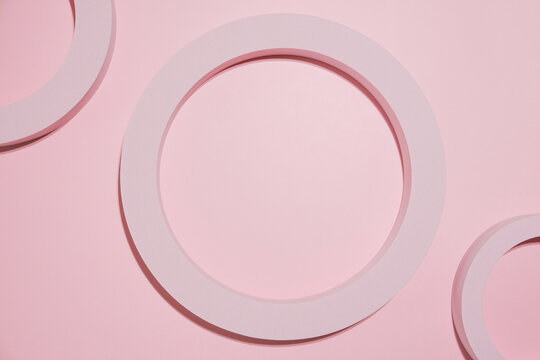 Abstract pink geometric composition with circular forms on pastel background. Top view