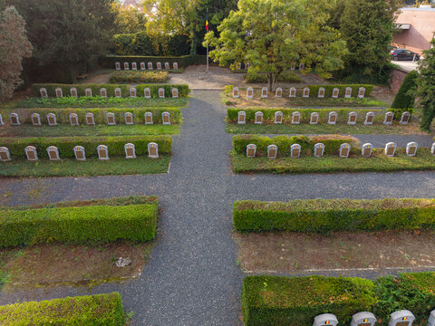 Zemst, Belgium - 03 October 2026: Aerial view of the Eppegem military cemetery featuring rows of World War I war graves, manicured hedges, and a central gravel path.