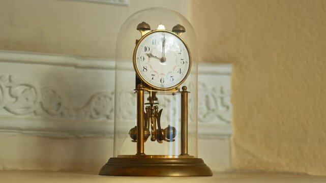 A retro table clock featuring a metal structural design encased within a glass dome. Innovative design elements.