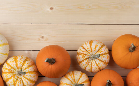 Flat lay arrangement with pumpkins on wooden background