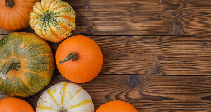 Flat lay arrangement with pumpkins on wooden background
