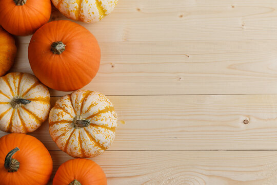 Flat lay arrangement with pumpkins on wooden background