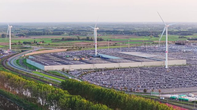 Aerial drone view of thousands of new import export cars parked in a sea port terminal. Commercial automotive supply chain and maritime freight logistics.