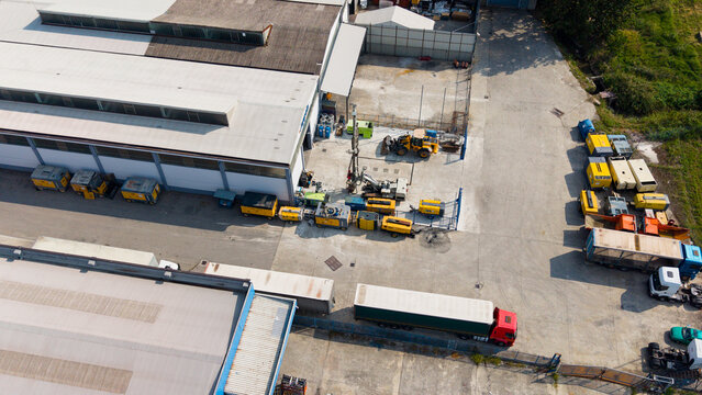 Milan, Lombardy, Italy - 25 September 2026: Aerial view of a construction and engineering equipment rental facility featuring various machinery, generators, and trucks parked in the yard.