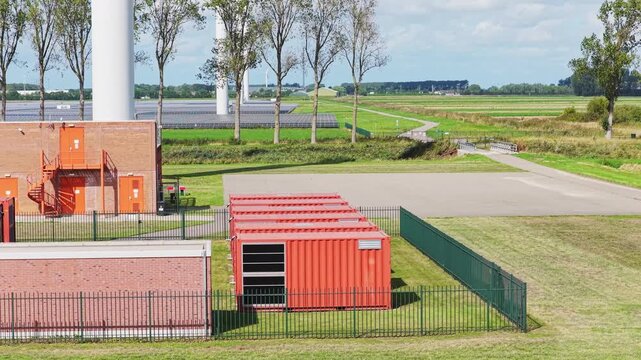 Aerial drone view of a battery energy storage system facility. Containers BESS units with transformers in a modern power grid station.