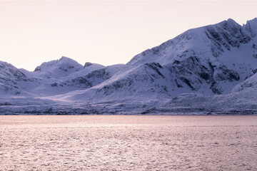 Majestic snow-covered mountains reflecting pastel twilight in a calm fjord, Northern Norway © Alberto
