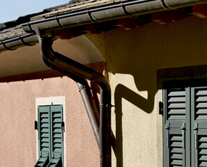 Double gutter downpipe on the slate roof of a country house. © Riccardo Arata