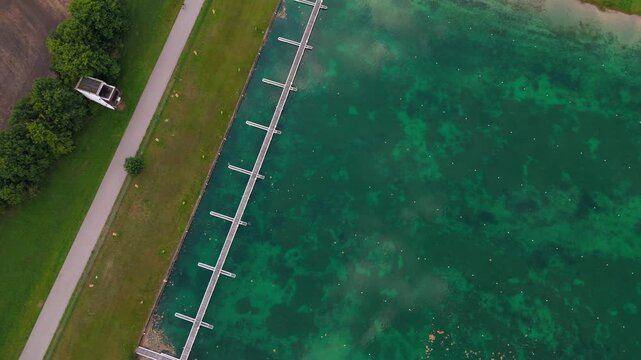Olympic Regatta Centre, Munich, Germany. Aerial drone view of rowing and canoe sprint venue with grandstands, jury tower, and scenic flatwater surrounded by nature and meadows.