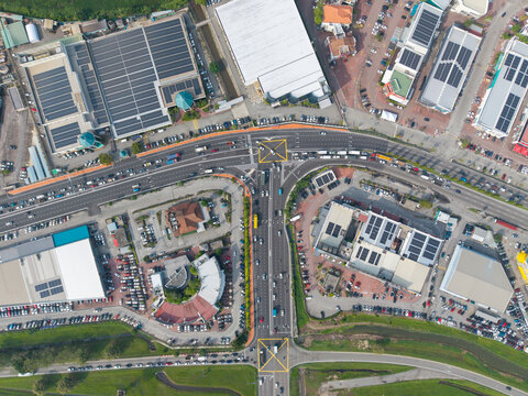 Simpang Ampat, Malaysia - 05 October 2026: Aerial view of PLUS Expressways at Juru showing the intersection with traffic, surrounding industrial buildings, and solar panels on rooftops.