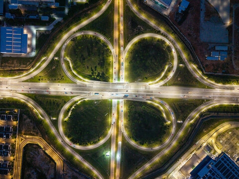 Simpang Ampat, Malaysia - 05 October 2026: Aerial view of the illuminated Batu Kawan cloverleaf interchange at night with surrounding industrial infrastructure and road networks.