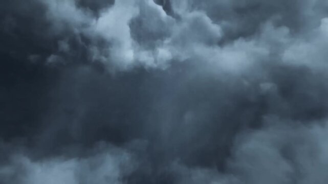 Dense storm clouds churn and swirl, shifting across a dark overcast sky