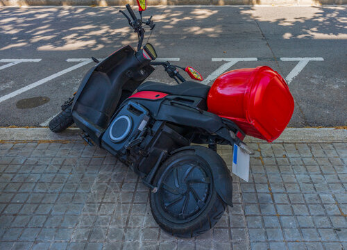 Electric Delivery Motorcycle Fallen by the Curb With Red Cargo Box