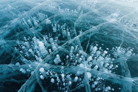 Frozen air bubbles trapped inside thick transparent lake ice creating intricate crystalline patterns during the cold winter season.