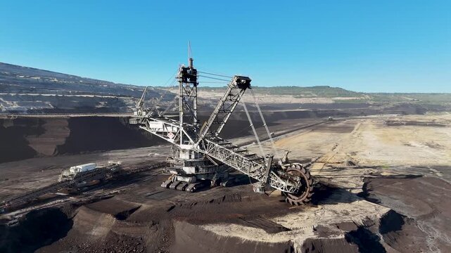 Bucket-wheel excavator with its cutting wheel, crawler units and conveyor system beside an exposed lignite face at Hambach mine, North Rhine-Westphalia, Germany.