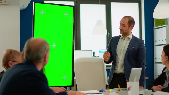 Greenscreen, businessman and presentation with presenter pointing at a vertical chroma key display during team briefing, for project strategy, office communication, collaboration and custom content.