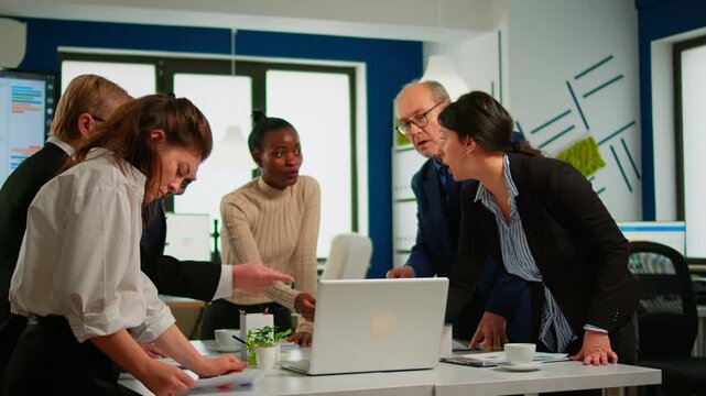Laptop, teamwork and discussion with business professionals reviewing digital data around a conference table in a modern office for analysis, collaboration, planning and project coordination.